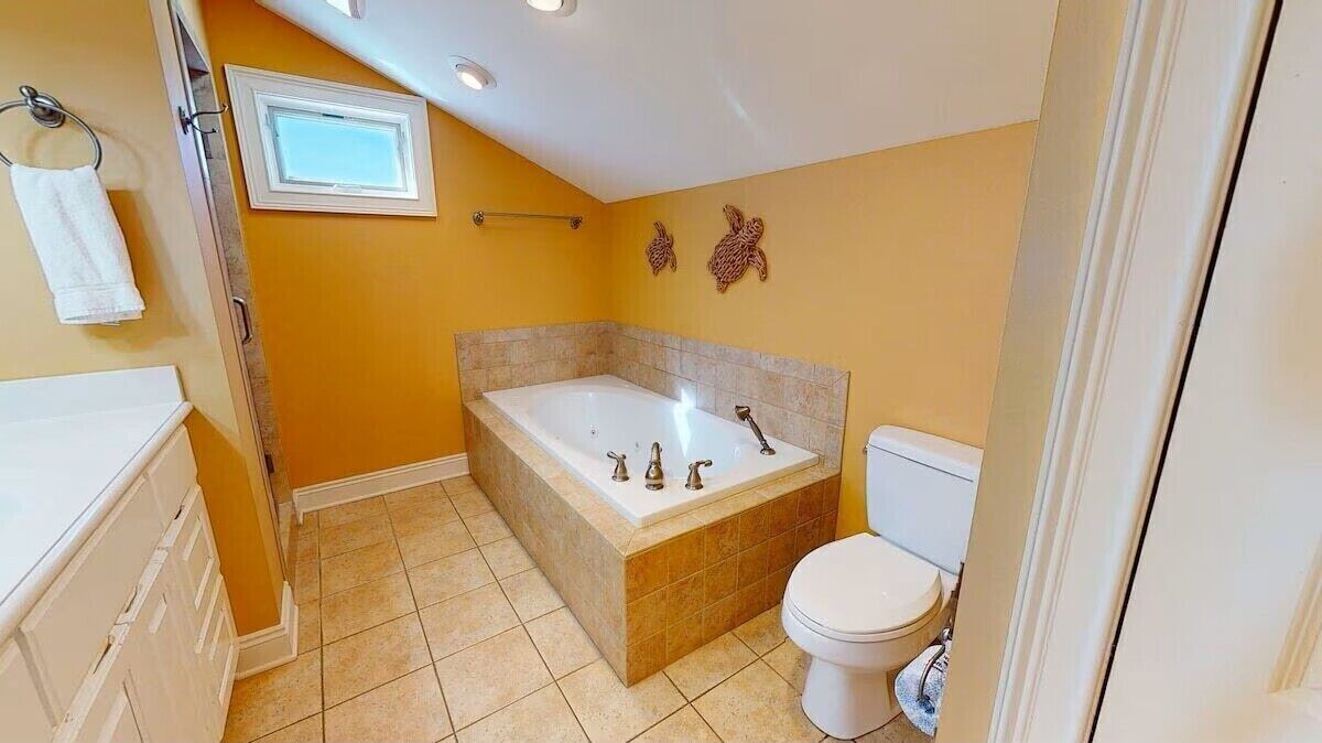 Ein Badezimmer mit Badewanne, Toilette und Handtuchhalter.