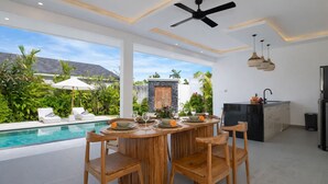 A modern kitchen with a black countertop, a built-in stove, and a sink. - Villa Kuwait Seminyak (Seminyak)