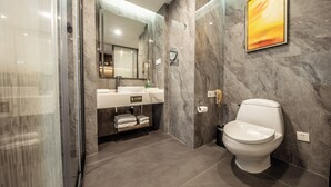 A modern bathroom with a glass shower enclosure, a marble sink, and a toilet. - ShenZhen Romanjoy International Hotel (Shenzhen)
