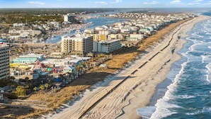 A coastal cityscape with a long beach, marina, and dense residential buildings. - Boardwalk Breeze, Oceanfront, Pool! Villa (Carolina Beach)