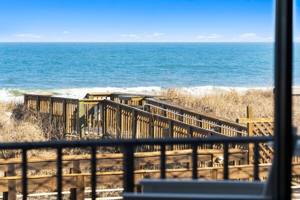 A wooden boardwalk leading to the ocean with a clear view of the sea. - Boardwalk Breeze, Oceanfront, Pool! Villa (Carolina Beach)