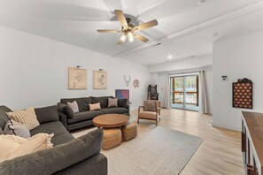 A modern living room with a sectional sofa, a round coffee table, a single chair, and a ceiling fan. - New Cozy Lodge w Arcade_Private Hot Tub_Cmty In/Outdoor Pools & Much More_Free Attraction Tickets (Hollister)