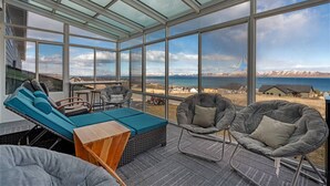 A modern interior with large windows, a sofa, chairs, and a small table.