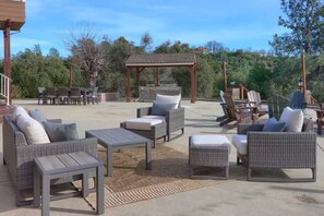 An outdoor patio with wicker furniture, a pergola, and a barbecue area. - NEW! Luxury Yosemite Estate-Pool-Hot Tub- 5BR 4.5BA-Sleeps 16-55 Private Acres. (Oakhurst)