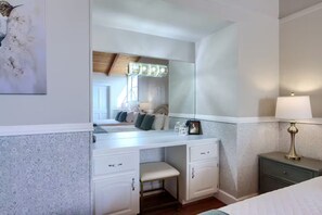 A bedroom with a white dresser, a bench, a bedside table with a lamp, and a large mirror. - NEW! Luxury Yosemite Estate-Pool-Hot Tub- 5BR 4.5BA-Sleeps 16-55 Private Acres. (Oakhurst)