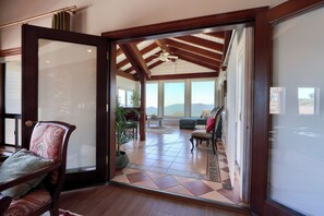 An open doorway leading to a room with a tiled floor, a ceiling fan, and a view of the outdoors. - NEW! Luxury Yosemite Estate-Pool-Hot Tub- 5BR 4.5BA-Sleeps 16-55 Private Acres. (Oakhurst)
