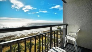 A balcony with a view of the ocean, a white chair, and a railing. - Beachfront Paradise - Stunning views - Stargazzing (Myrtle Beach)