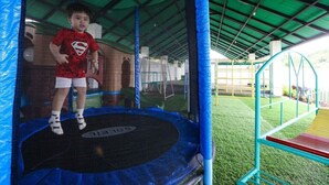 A trampoline under a green roof structure.