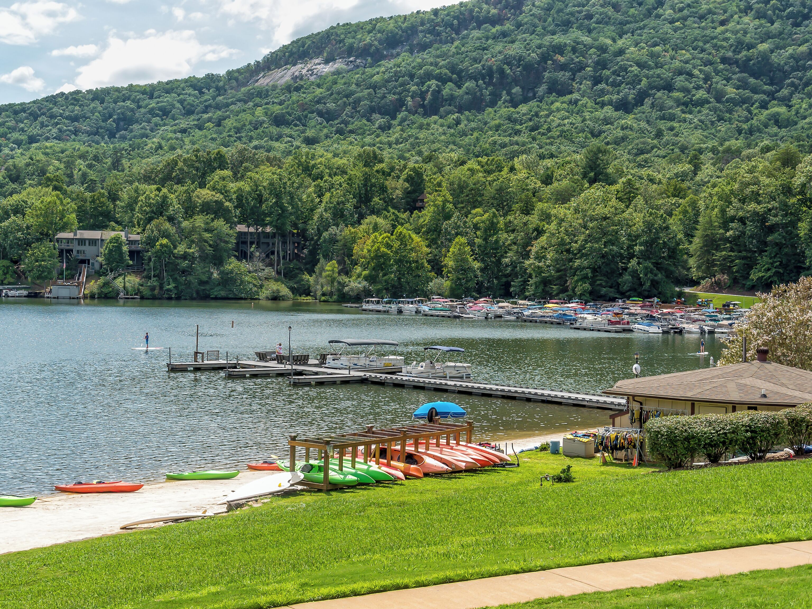 A lakeside dock with kayaks and a covered seating area.