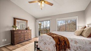 A bedroom with a bed, dresser, and a large window. - Scenic Solitude in Lake Lure (Lake Lure)