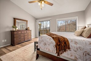 Ein Schlafzimmer mit Bett, Schminktisch und einem großen Fenster.