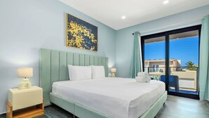 A modern hotel room with a large bed, a nightstand with a lamp, a painting on the wall, and a view of the outside. - NEW 4BR3.5BA Home w/Private Pool ~ Good Location (Noord)
