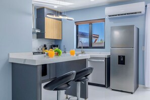 A modern kitchen with a central island, stainless steel appliances, and a window with a view. - New 4BR3.5BA Retreat w/Prvt Pool ~ CentralLocation (Noord)