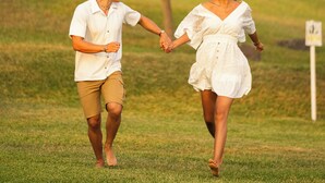 A couple holding hands walking on a grassy path with a tree in the background. - Ranch Pachacamac (Pachacamac)