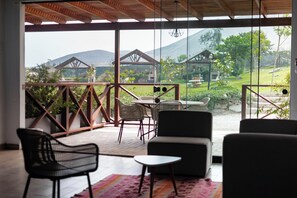 A covered outdoor seating area with a view of a mountainous landscape. - Ranch Pachacamac (Pachacamac)