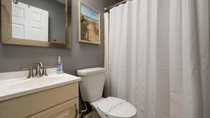 A bathroom with a toilet, sink, and shower curtain. - 3 minutes to Beach, 2BD/2BA Near 28th St Boardwalk (Ocean City)