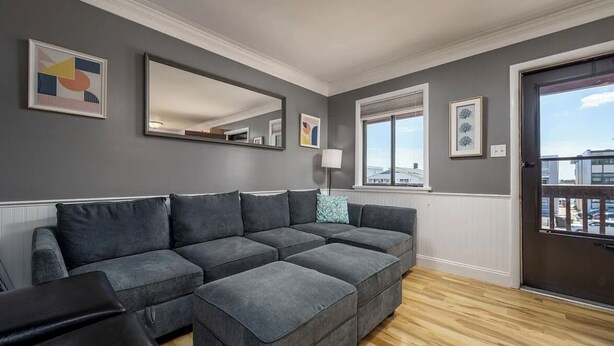 A living room with a sectional sofa, a large mirror, and artwork on the walls. - 3 minutes to Beach, 2BD/2BA Near 28th St Boardwalk (Ocean City)