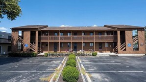 A two-story building with a central balcony, a parking lot in front, and a clear sky. - 3 minutes to Beach, 2BD/2BA Near 28th St Boardwalk (Ocean City)