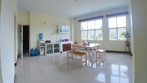 Una cocina amplia con comedor, ventanas grandes y dispensador de agua.