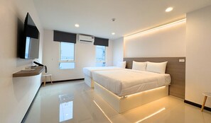 Et moderne hotelværelse med seng, sengebord, tv, vinduer og en aircondition.