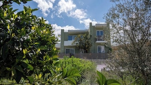 Un bâtiment moderne à deux étages, doté d’un balcon et entouré de verdure.
