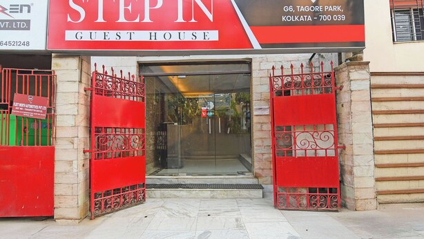 L’entrée d’un hôtel, avec un portail rouge et une enseigne indiquant qu’il s’agit d’une maison d’hôtes.