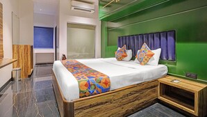 A modern hotel room with a large bed, a green accent wall, and a wooden headboard. - Fabhotel Dukes Plaza (Mumbai)