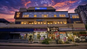 A hotel with a sign 'fab hotels' and multiple storefronts including 'MOMOSTATION CAFE' and 'LASER SPECS REMOVAL'. - Fabhotel Dukes Plaza (Mumbai)