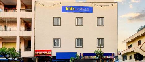 Un edificio con un cartel que dice 'Tab Hotels' y un local comercial en la planta baja.