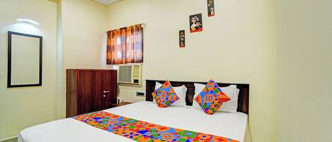 A bedroom with a bed, a ceiling fan, a wall-mounted air conditioner, and a door.