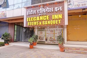 Een hotelschiltje met 'Hotel Elegance Inn' en 'Banquet & Rooms' in verschillende talen.