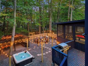 A deck with a hot tub, outdoor seating, and string lights. - Private Poconos Retreat! HotTub, GameRoom, FirePit (Tobyhanna)