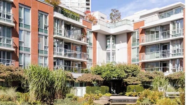 A modern apartment building with a reflective pond and lush greenery in the foreground. - Vancouver downtown apartment (Vancouver)