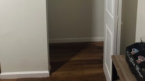 Ein Zimmer mit Holzboden, einem Kleiderschrank mit Platz zum Aufhängen und einer Kaffeebar.