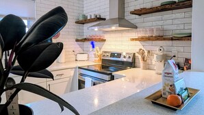 Een moderne keuken met witte metrotegels, roestvrijstalen apparatuur en een centraal kookeiland.