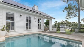 A white house with a swimming pool, outdoor seating, and a garden. - The Homestead at Farmhouse Hunter Valley (Pokolbin)