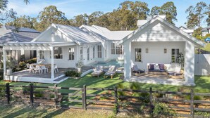 A white house with a covered patio, a swimming pool, and a fenced yard. - The Homestead at Farmhouse Hunter Valley (Pokolbin)