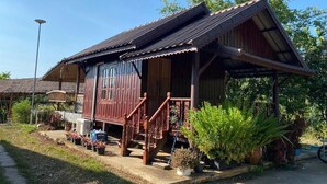 A wooden house with a porch, steps, and potted plants. - Phuthiptara Resort (Khlung)