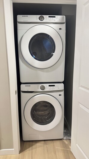 A Samsung front-loading washer and dryer stacked in a narrow space.
