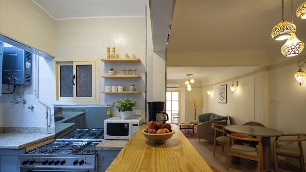 A kitchen with a stove, microwave, and a wooden countertop.