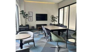 A modern meeting room with a large table, several chairs, a flat-screen TV, and large windows. - Cozy apartment in Americana 16 (Guadalajara)