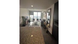 A modern apartment with a kitchen, dining area, and living room with large windows. - Cozy apartment in Americana 16 (Guadalajara)