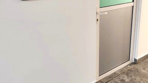 Une porte avec une pancarte indiquant « DÉCHETS » fixée au mur à côté.