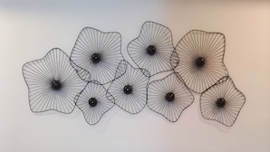 Ein Bett mit zwei Kissen, einem Kopfteil und einer Wand mit einem dekorativen Metallteil.