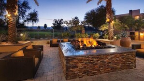 An outdoor fire pit area with seating, surrounded by palm trees and plants. - Relaxing Studio - Marriott Shadow Ridge The Enclaves - Short Drive to Coachella (Palm Desert)