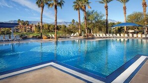 A pool with clear blue water, surrounded by lounge chairs and palm trees, with a mountain view in the background. - Relaxing Studio - Marriott Shadow Ridge The Enclaves - Short Drive to Coachella (Palm Desert)