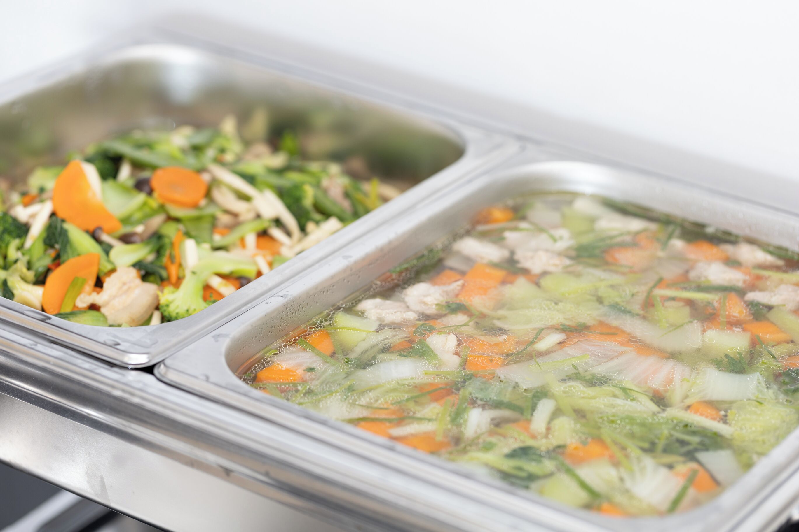 Un buffet composé de deux sections : une proposant des légumes sautés et l’autre, une soupe claire.