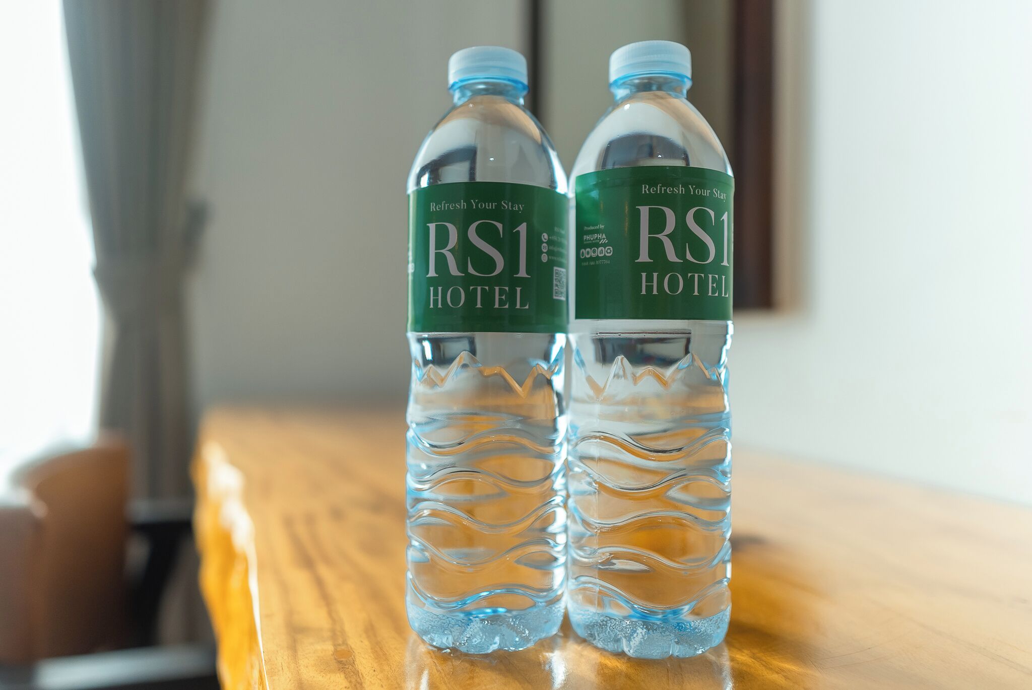 Two water bottles with labels on a wooden surface.
