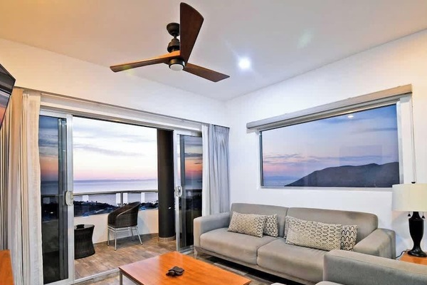 The sitting area offers comfortable sofas, a coffee table, and a wall-mounted TV