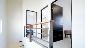 A modern interior with a staircase, a door, and a small table.